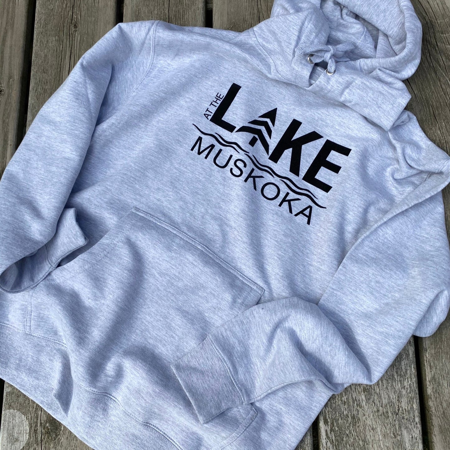 Medium weight hoodie in light grey heather. Logo on the front of hoodie reads AT THE LAKE MUSKOKA in black HTV.